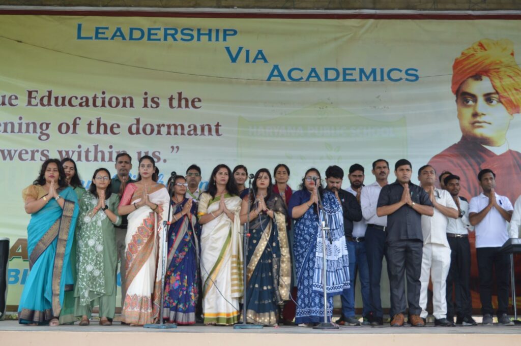 Faculty and staff gathered on stage during academic event at HPS Narnaul