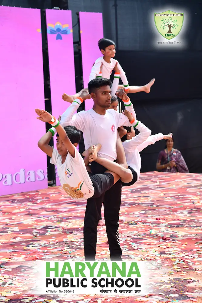 Students performing a patriotic acrobatic dance on a stage in HPS Narnaul cultural event